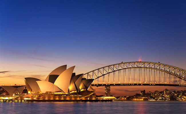 Sydney, Australia - September 5, 2013: Beautiful Opera house view at twilight time with vivid sky and illumination on the bridge.