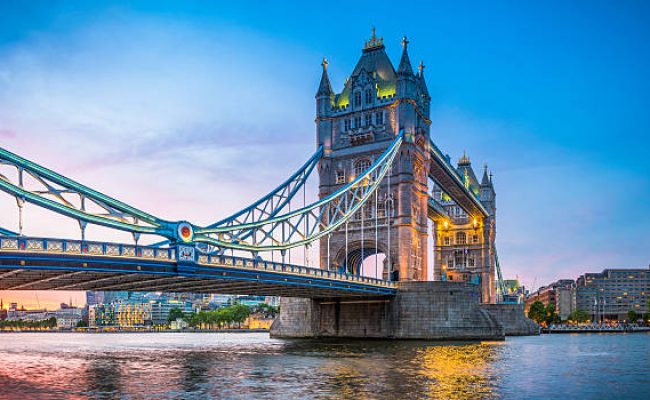 Summer sunset skies above the iconic span of Tower Bridge above the slow moving waters of the River Thames in the heart of London, Britain's vibrant capital city.
