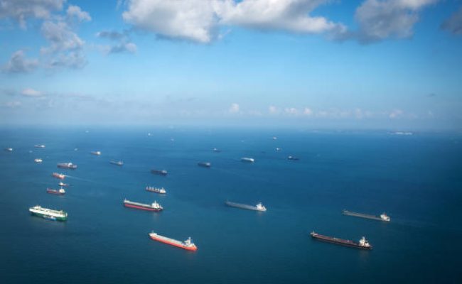 Singapore, Singapore: Transportation and Container ships wait on the ocean in front of the port of Singapore.